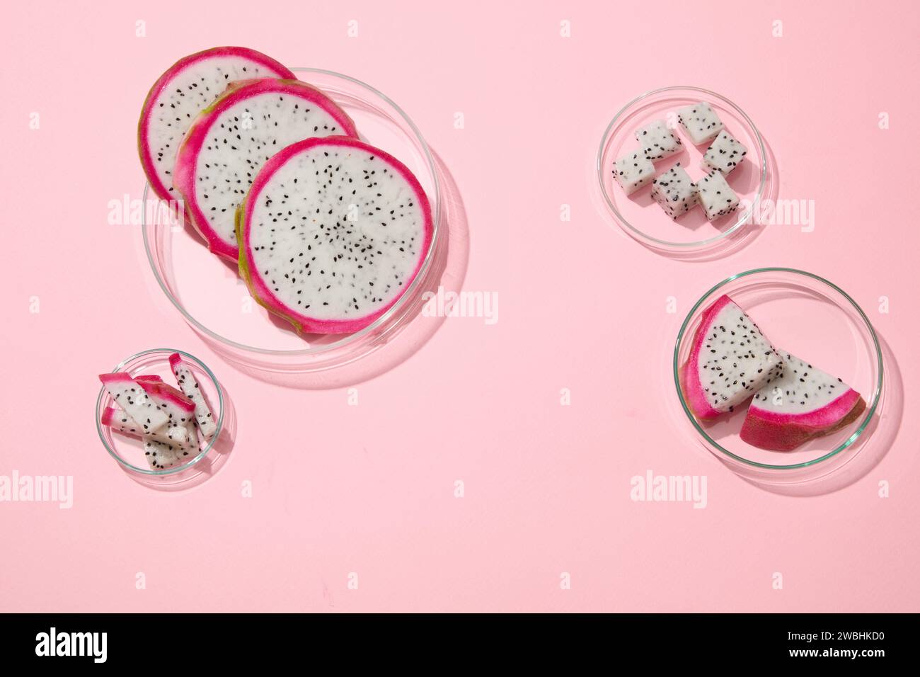 Alcuni piatti di Petri di vetro contenenti frutta bianca del drago sono esposti con un'area vuota al centro. Dragon Fruit (Hylocereus) è una sana fonte di fi Foto Stock