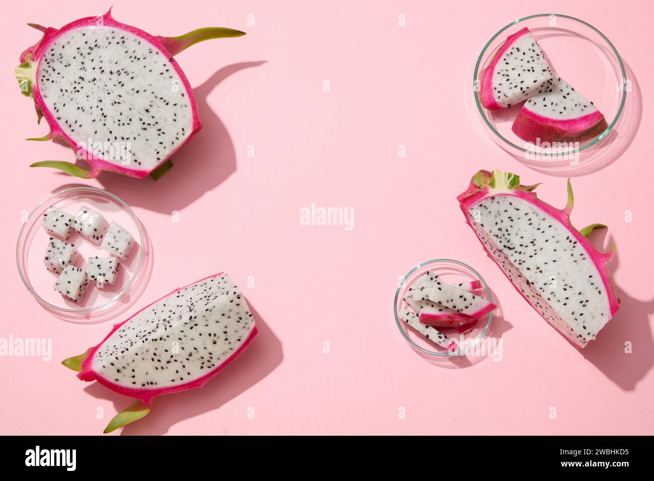 La frutta bianca del drago tagliata a cubetti e a fette è disposta su sfondo rosa pastello. Spazio vuoto al centro per la presentazione del prodotto di bellezza D Foto Stock