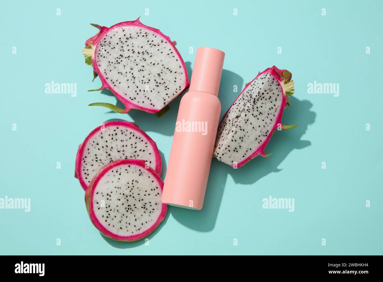 Vista dall'alto di una bottiglia di colore pastello disposta con frutta di drago bianco. Il frutto del drago (Hylocereus) è ricco di nutrienti che possono aiutare a trattare il colou Foto Stock
