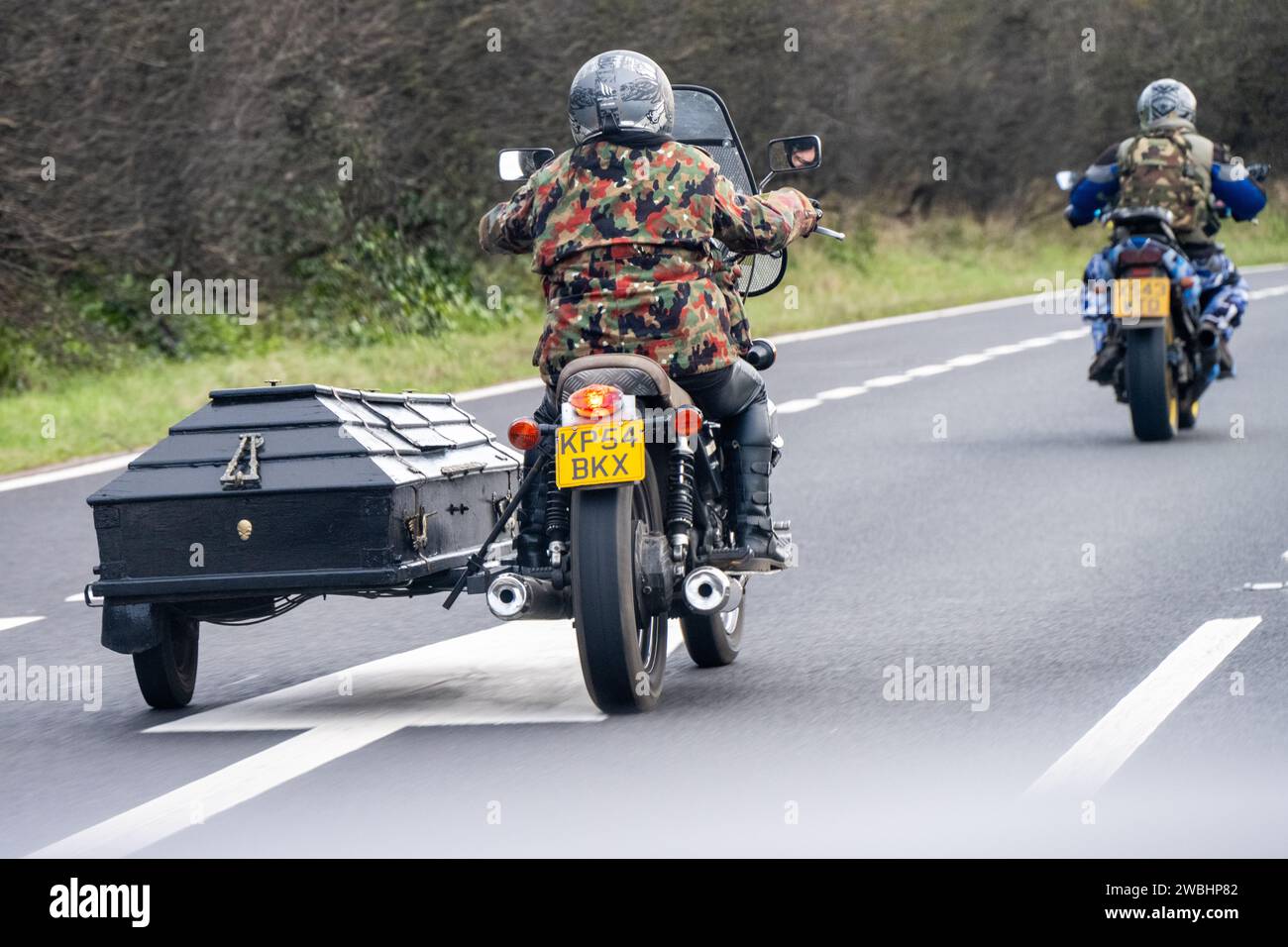 Un paio di motociclisti che viaggiano in abbigliamento mimetico con un'auto laterale unica su una delle moto Foto Stock