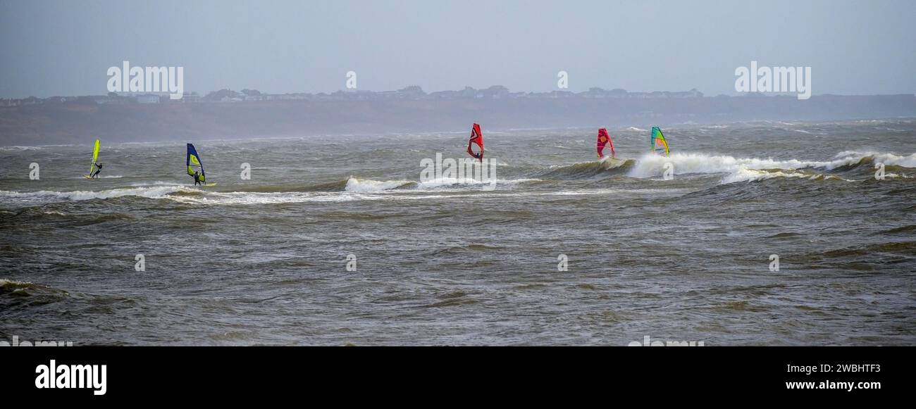 Gli amanti del windsurf si divertono con i venti e le onde di vento Foto Stock