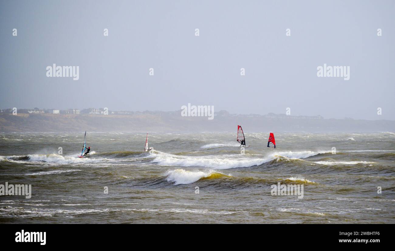 Gli amanti del windsurf si divertono con i venti e le onde di vento Foto Stock