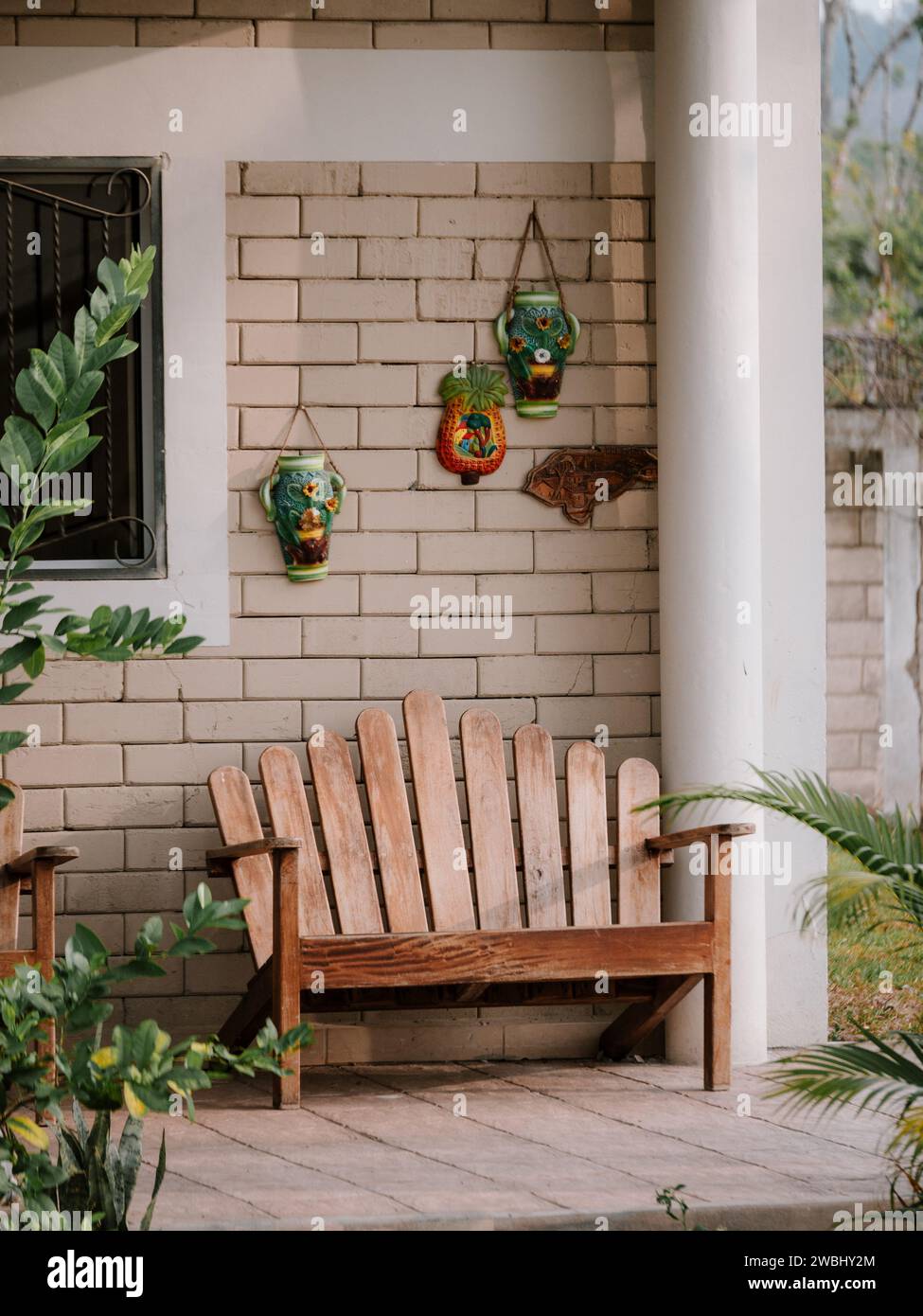 Una rustica panca in legno posizionata su un elegante patio, con design a vaso sospeso Foto Stock