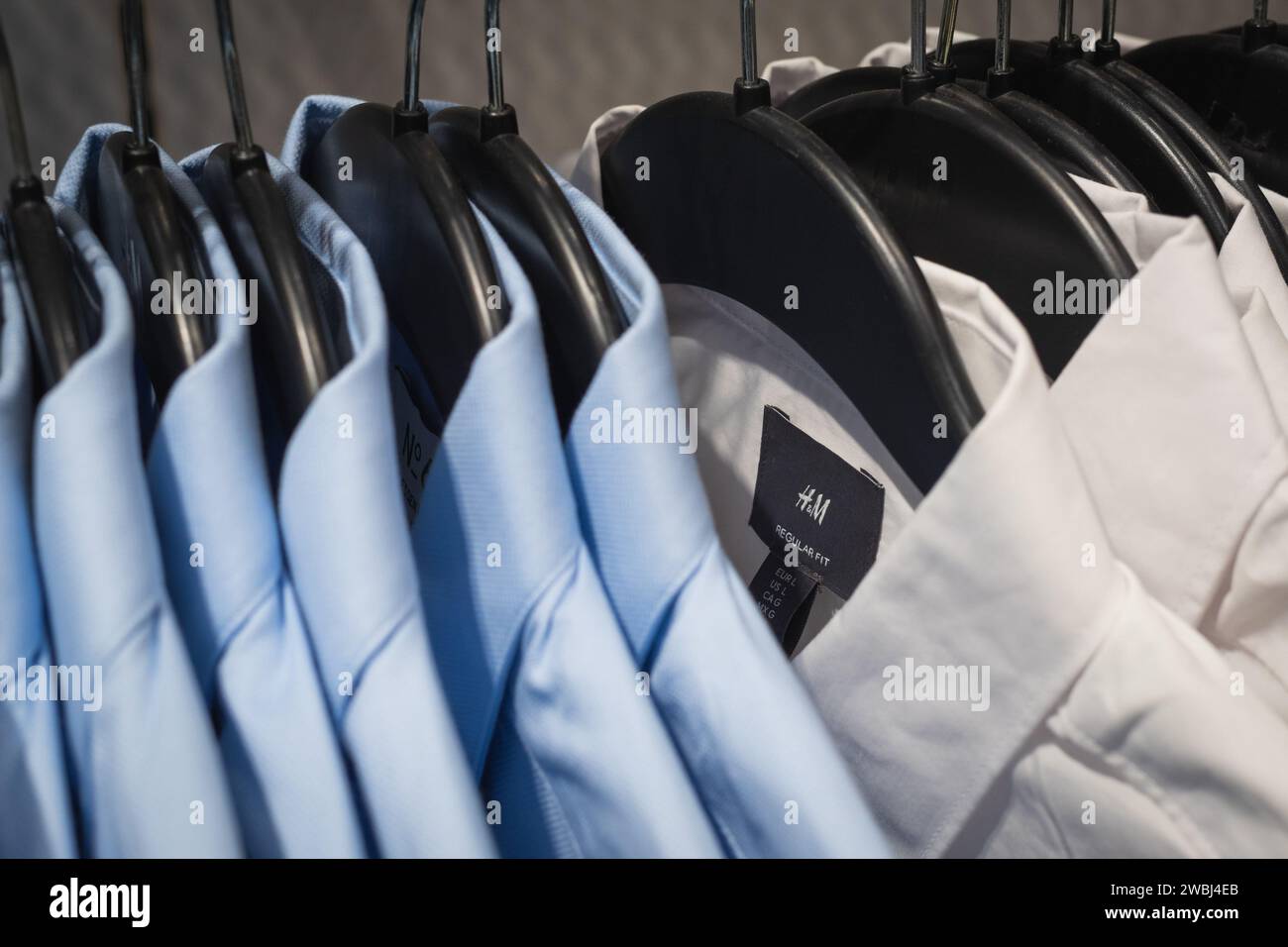 Bangkok, Thailandia - 10 dicembre 2023: Magliette H&M (con l'etichetta) appese a un rack in un negozio. Foto Stock