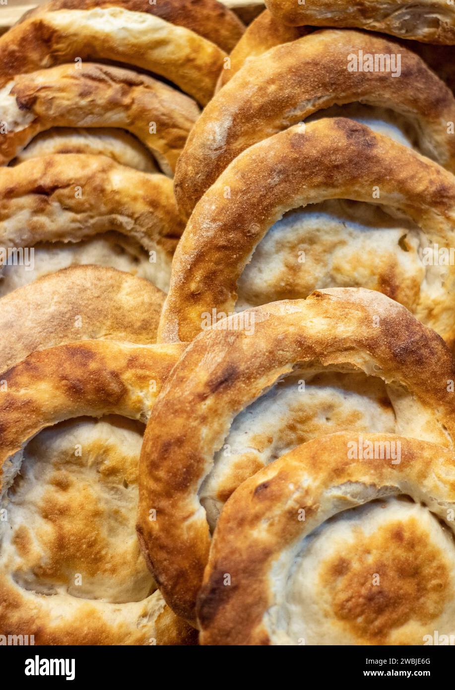 Esposizione di panini fatti a mano sul bancone di una moderna panetteria per invogliare i clienti ad acquistare Foto Stock Esposizione di panini fatti a mano sul bancone di una moderna panetteria per invogliare i clienti ad acquistare Foto Stock