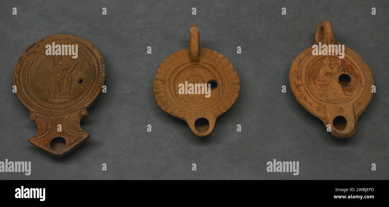 Lampade a olio in argilla romane. Quelli a sinistra e a destra sono decorati con una rappresentazione di una musa. Quello centrale raffigura Selene. Museo Archeologico Nazionale. Lisbona, Portogallo. Foto Stock
