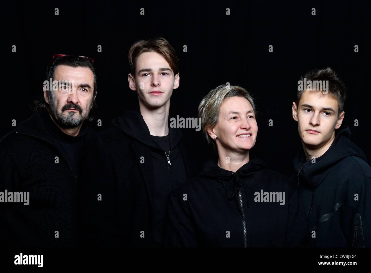 foto in studio di quattro persone che indossano abiti neri sullo sfondo nero Foto Stock