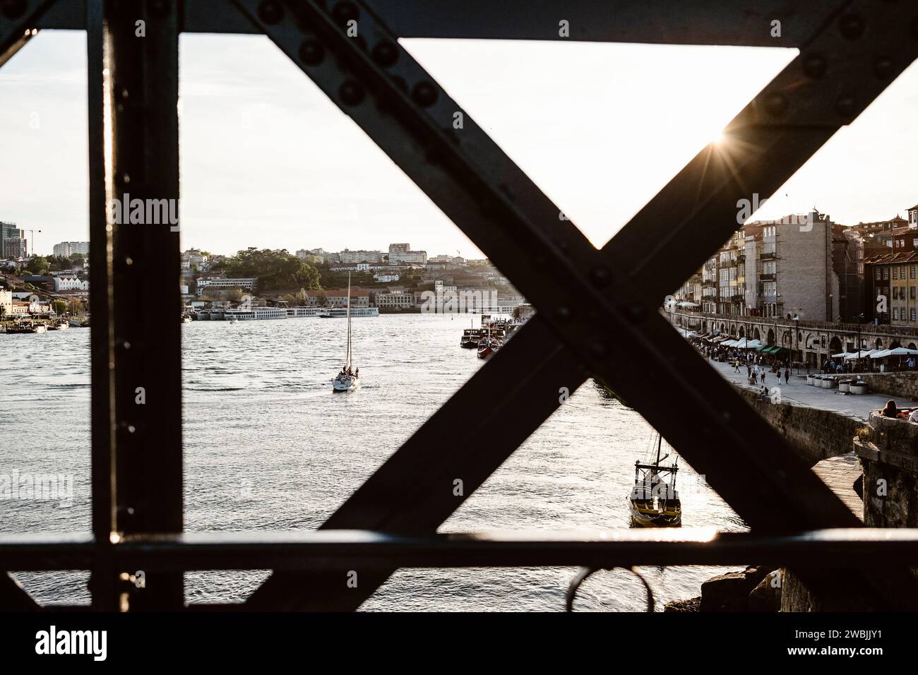 Vista al tramonto sul lungofiume di Porto con il famoso ponte di ferro di fronte, nel nord del Portogallo Foto Stock
