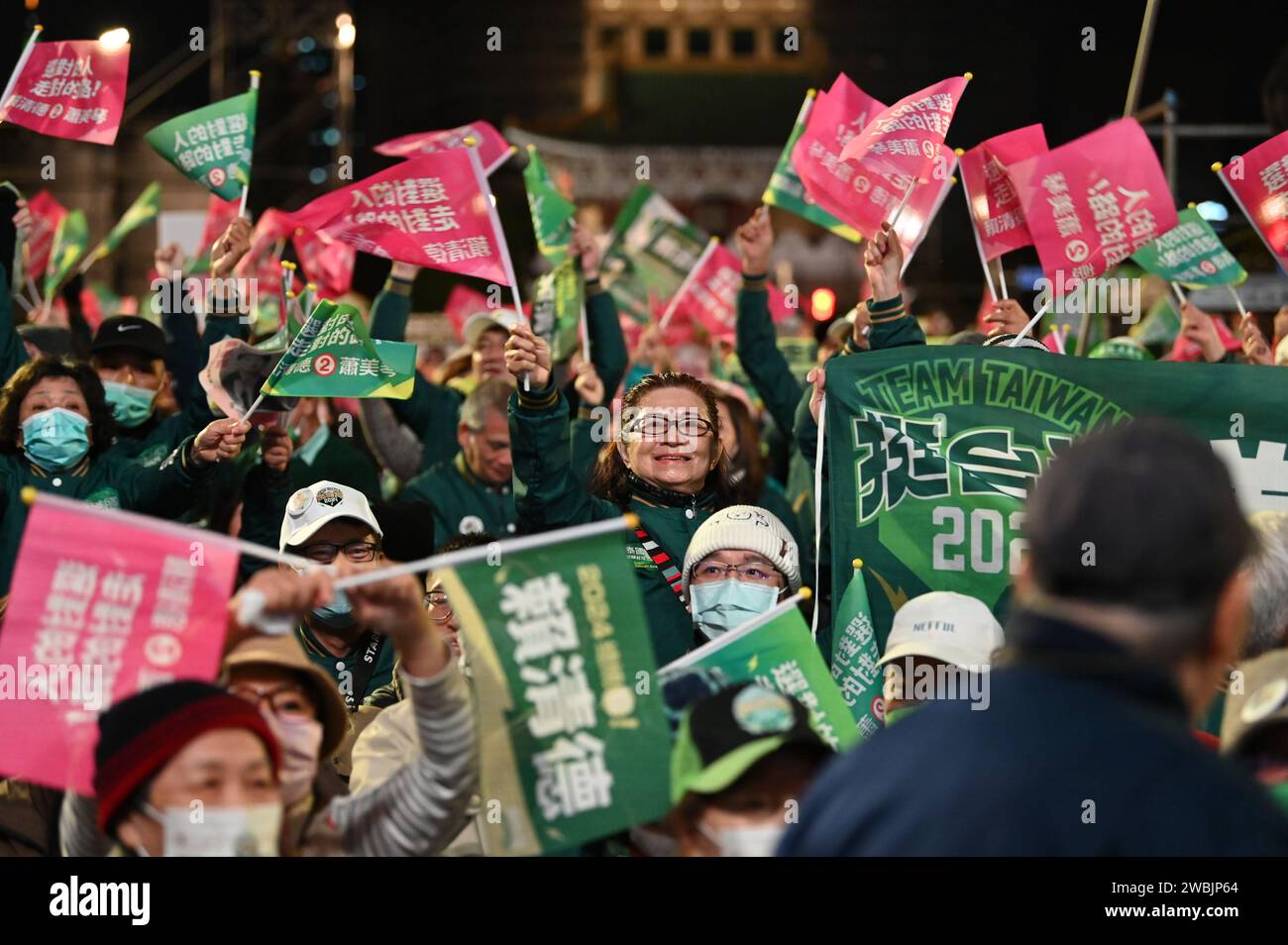 Taipeh, Taiwan. 11 gennaio 2024. La gente ondeggia bandiere a una manifestazione elettorale del Partito Progressista Democratico. Sabato prossimo a Taiwan verranno eletti un nuovo parlamento e un nuovo presidente. Una questione fondamentale nella campagna elettorale è stata la tesa relazione con la Cina, che vuole riunire l'isola con la terraferma - se necessario con mezzi militari. Credito: Johannes Neudecker/dpa/Alamy Live News Foto Stock