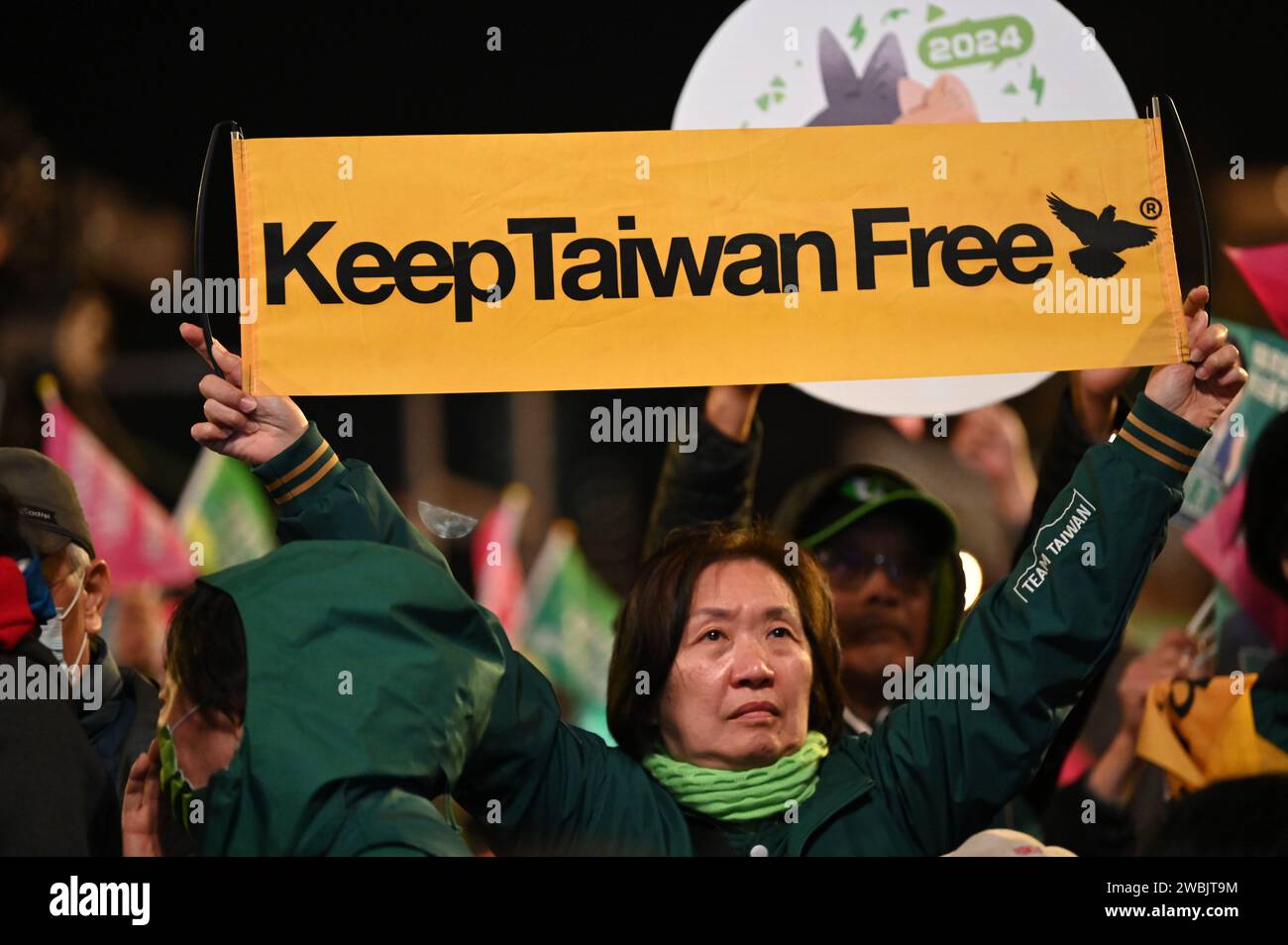 Taipeh, Taiwan. 11 gennaio 2024. Una donna tiene uno striscione con la scritta "Keep Taiwan Free" in una manifestazione elettorale del Partito Progressista Democratico (DPP). Sabato prossimo a Taiwan verranno eletti un nuovo parlamento e un nuovo presidente. Una questione fondamentale nella campagna elettorale è stata la tesa relazione con la Cina, che vuole riunire l'isola con la terraferma - se necessario con mezzi militari. Credito: Johannes Neudecker/dpa/Alamy Live News Foto Stock