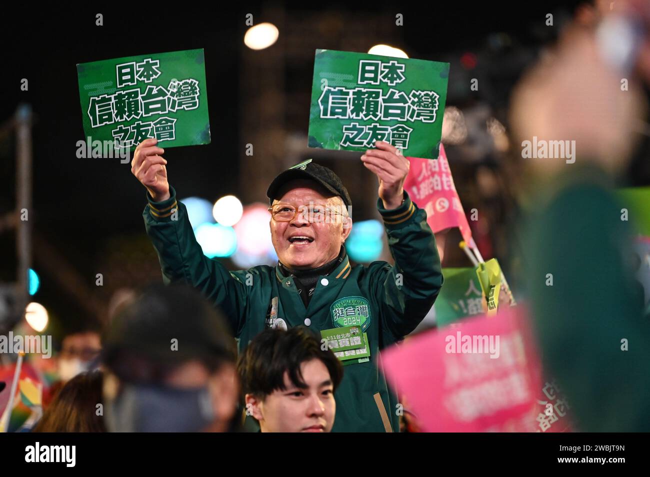 Taipeh, Taiwan. 11 gennaio 2024. Un uomo tiene manifesti che leggono "amici di taiwanesi che vivono in Giappone sostengono Lai" durante una manifestazione elettorale del Partito Progressista Democratico. Sabato prossimo a Taiwan verranno eletti un nuovo parlamento e un nuovo presidente. Una questione fondamentale nella campagna elettorale è stata la tesa relazione con la Cina, che vuole riunire l'isola con la terraferma - se necessario con mezzi militari. Credito: Johannes Neudecker/dpa/Alamy Live News Foto Stock