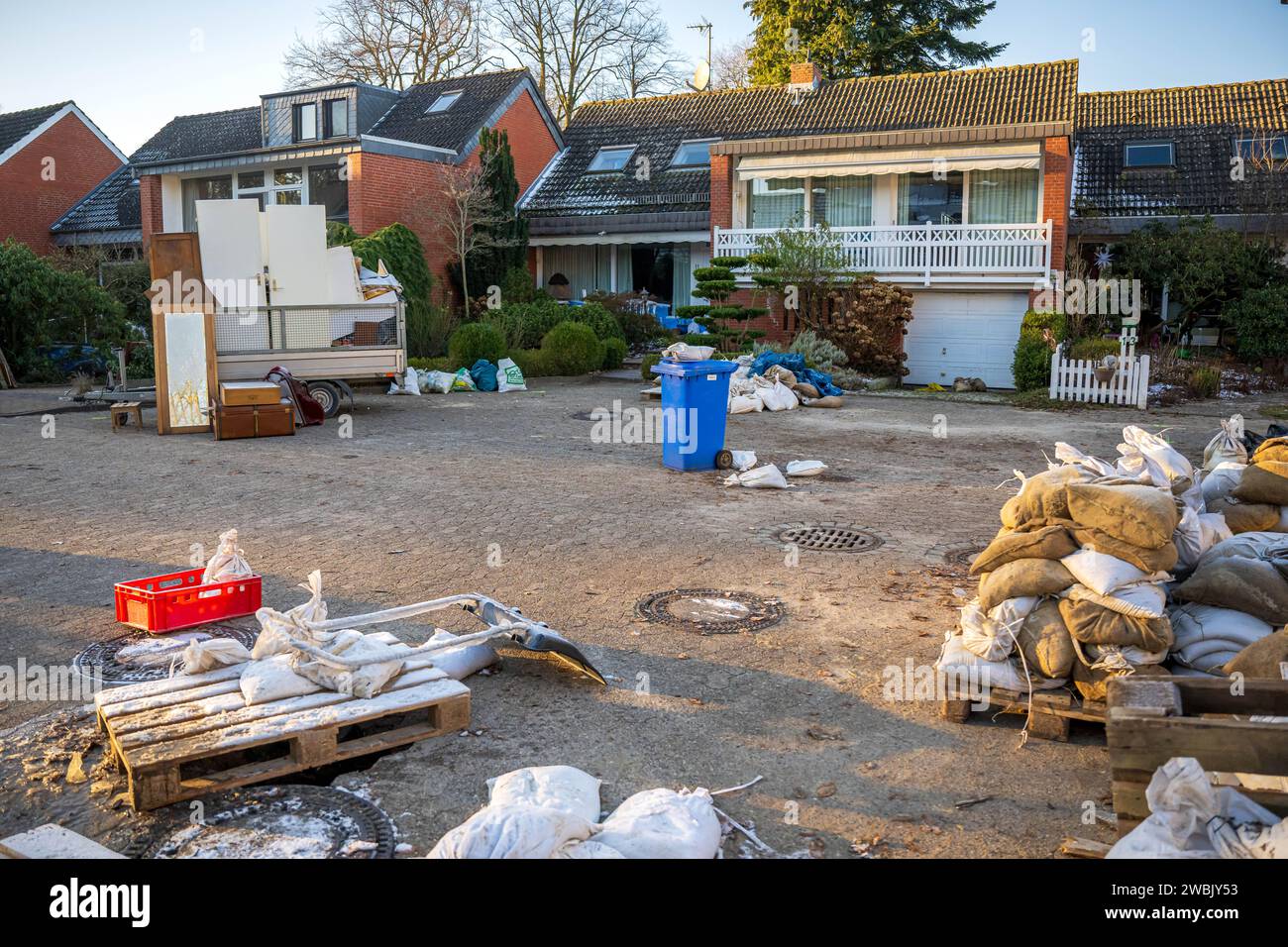Lilienthal, Germania. 10 gennaio 2024. Sacchi di sabbia e rifiuti voluminosi davanti alle case colpite dalle inondazioni. Il comune di Lilienthal, vicino a Brema, è stato gravemente colpito dalle inondazioni fin da Natale. Dozzine di case e appartamenti furono evacuati e altre case furono temporaneamente prive di elettricità o gas. Le acque alluvionali stanno ora diminuendo e la situazione si sta attenuando. Molti residenti hanno iniziato a ripulire. (A dpa-KORR "ripulire dopo le inondazioni - "come gestiremo?") Crediti: Sina Schuldt/dpa/Alamy Live News Foto Stock