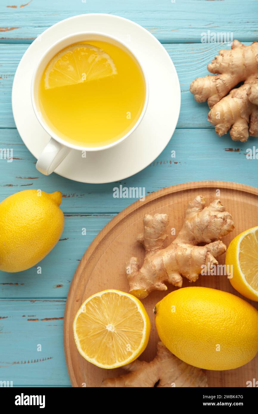 Tè allo zenzero con limone e miele su sfondo di legno blu. Foto verticale. Foto Stock