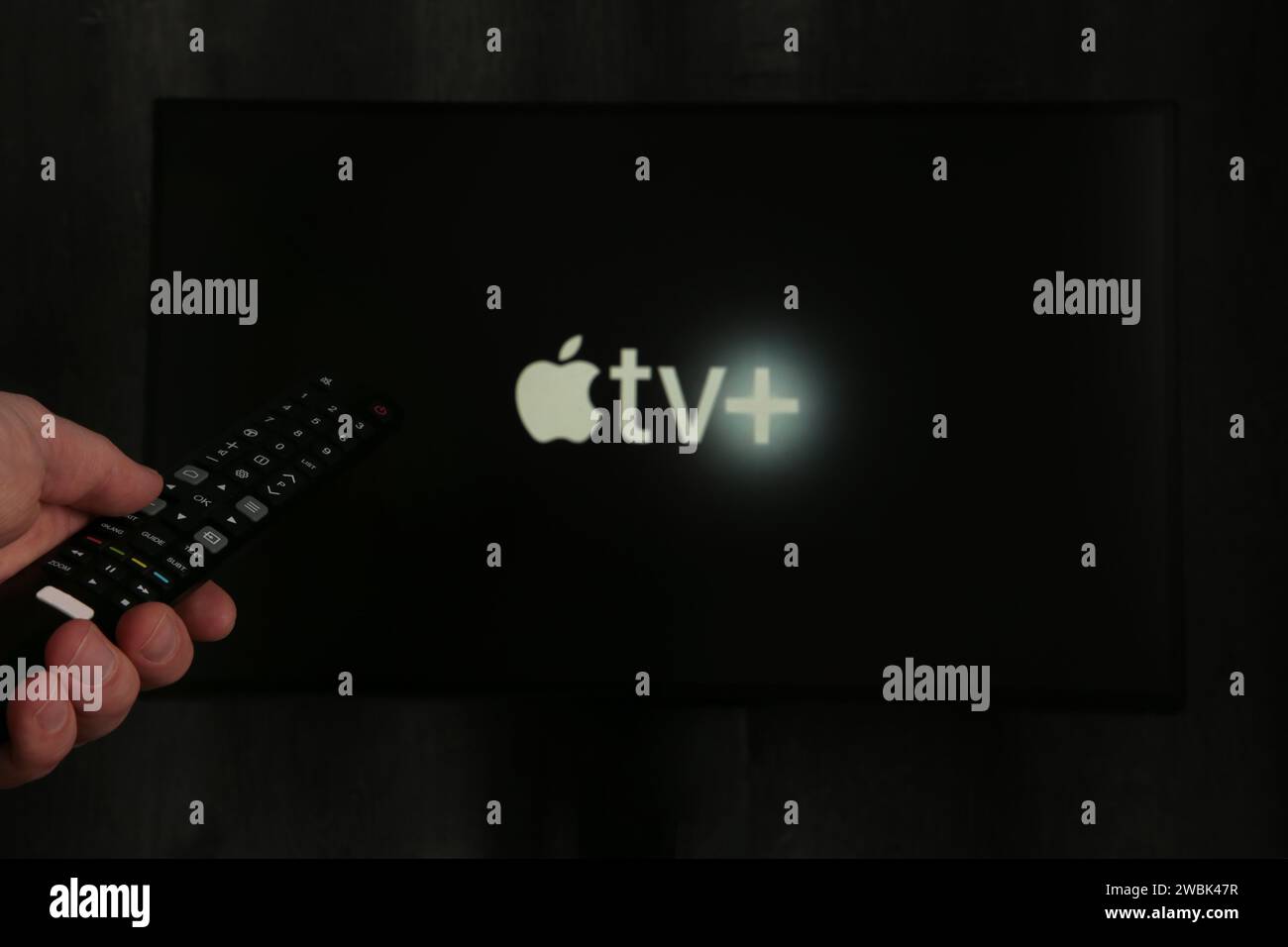 Nikolaev, Ucraina - 20 novembre 2021. Man ha un telecomando con il nuovo schermo Apple TV sul TV. Vista dall'alto. Foto Stock