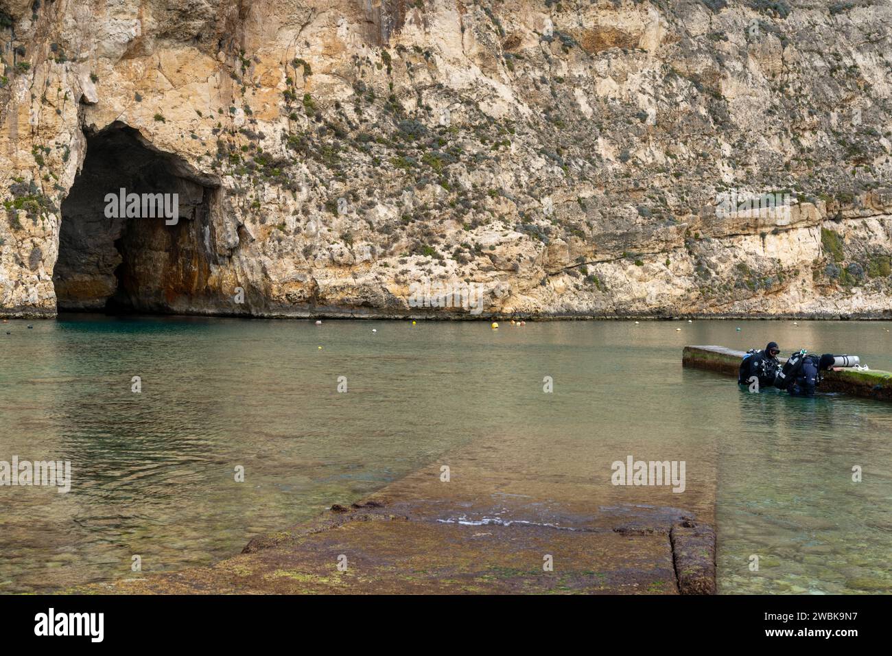 Dwejra, Malta - 19 dicembre 2023: Due subacquei che si preparano a fare immersioni nel Mare interno e nei siti di immersione Blue Hole sull'isola di Gozo a Malta Foto Stock