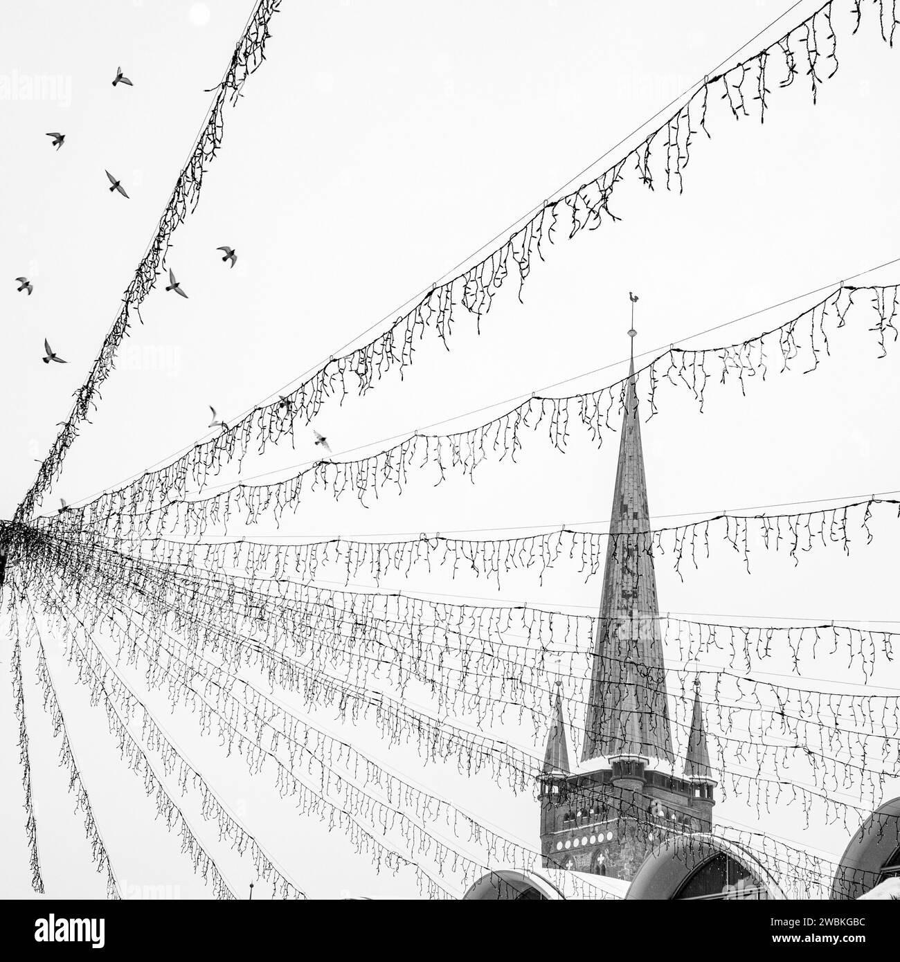 Germania, Schleswig-Holstein, Lübeck, torre della chiesa e luci delle fate Foto Stock