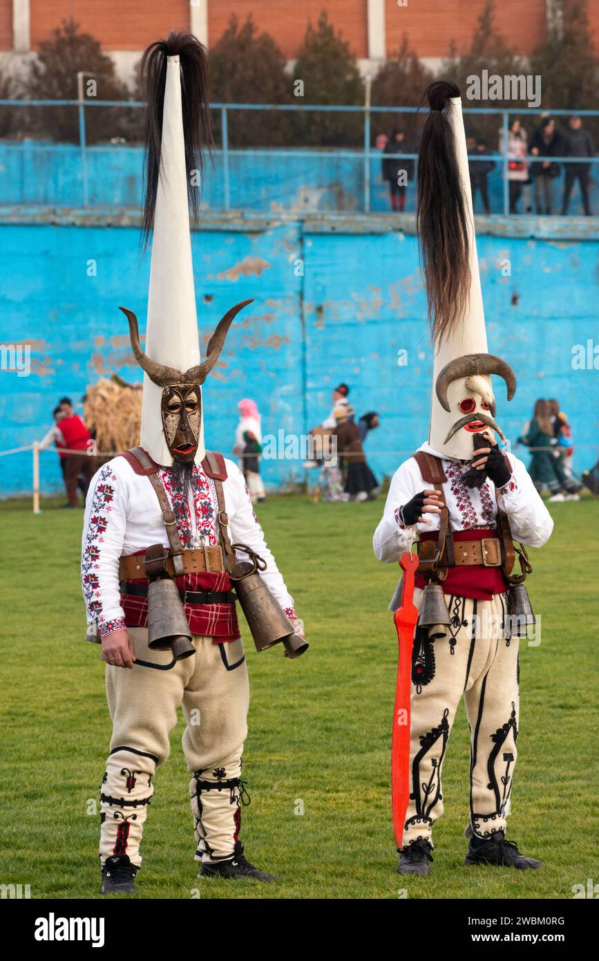 Ballerini Kukeri dalla Bulgaria centrale con costumi intricati e maschere coniche alte distintive al festival Simitlia di Simitli, Bulgaria, Europa Foto Stock