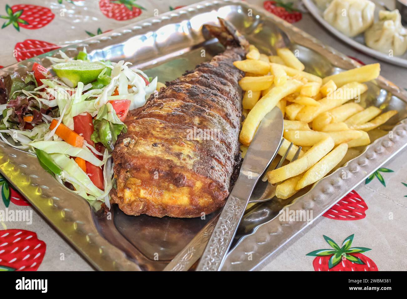 Pesce fritto con patatine fritte su un piatto rustico. Piatto di pesce - pesce fritto con patatine fritte e verdure. Nessuno, concentrazione selettiva Foto Stock