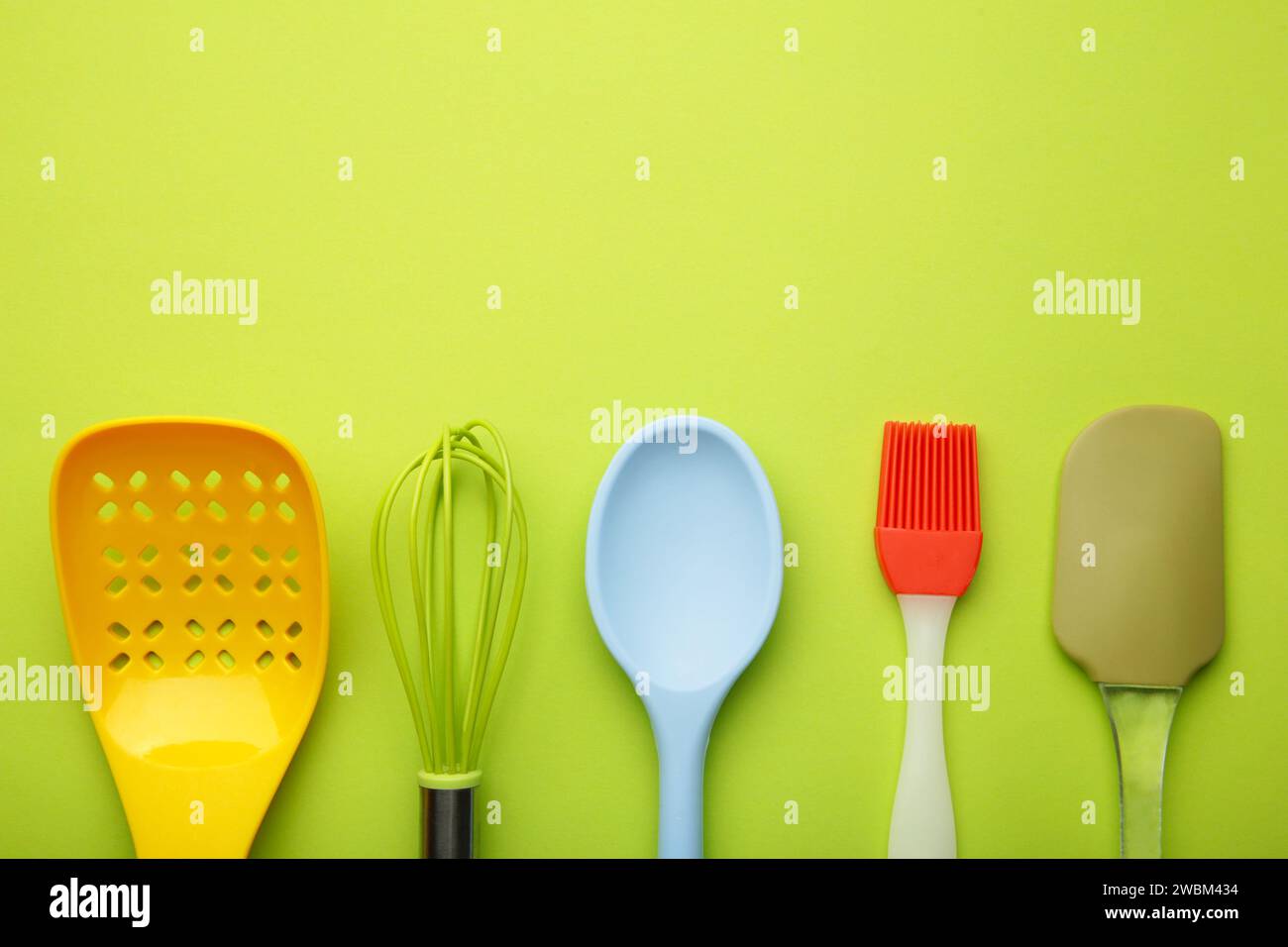 diversi utensili da cucina con vista dall'alto su sfondo verde. Elettrodomestici da cucina. Foto Stock