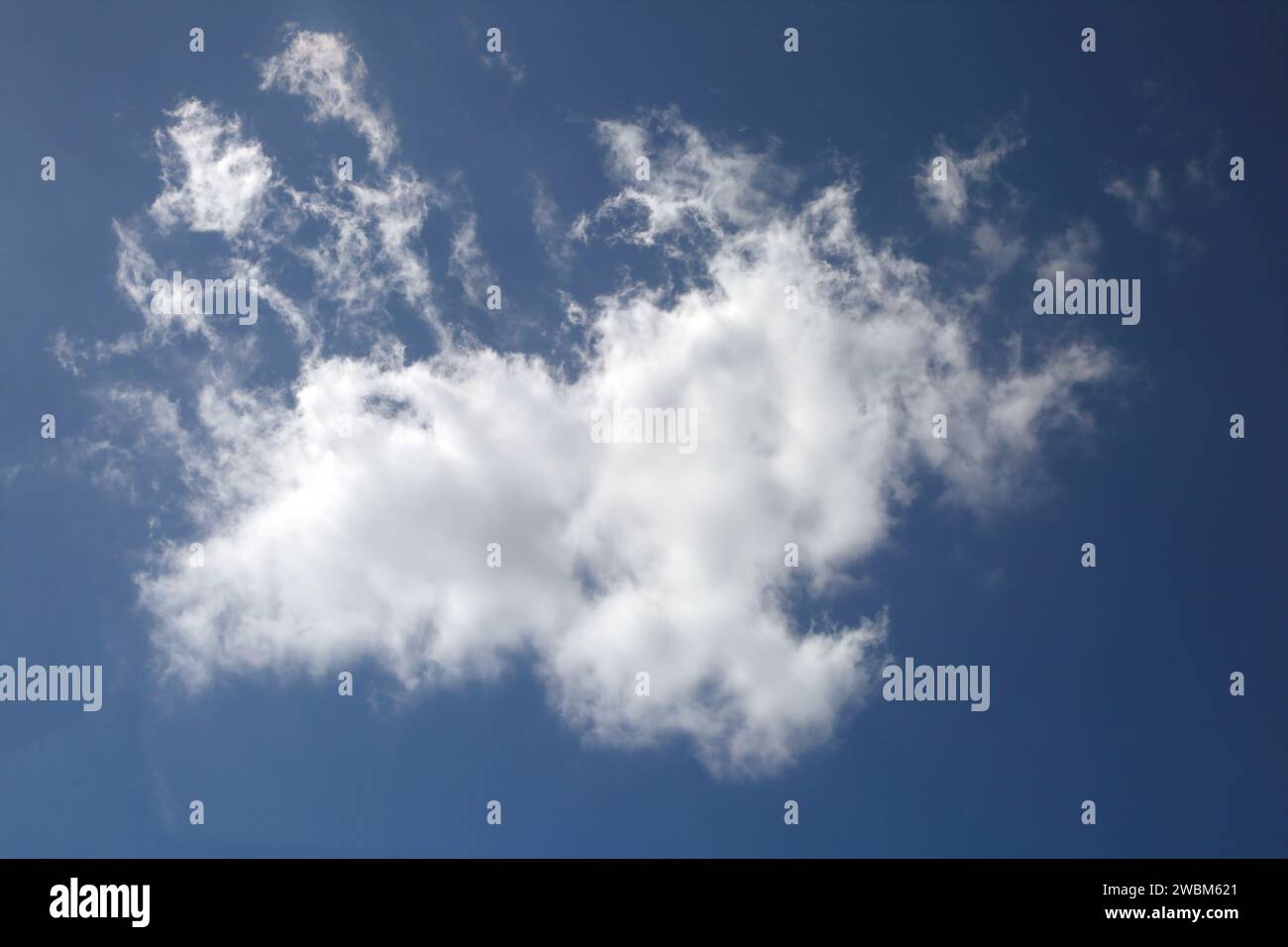 Nuvola bianca che si separa in Blue Sky Foto Stock