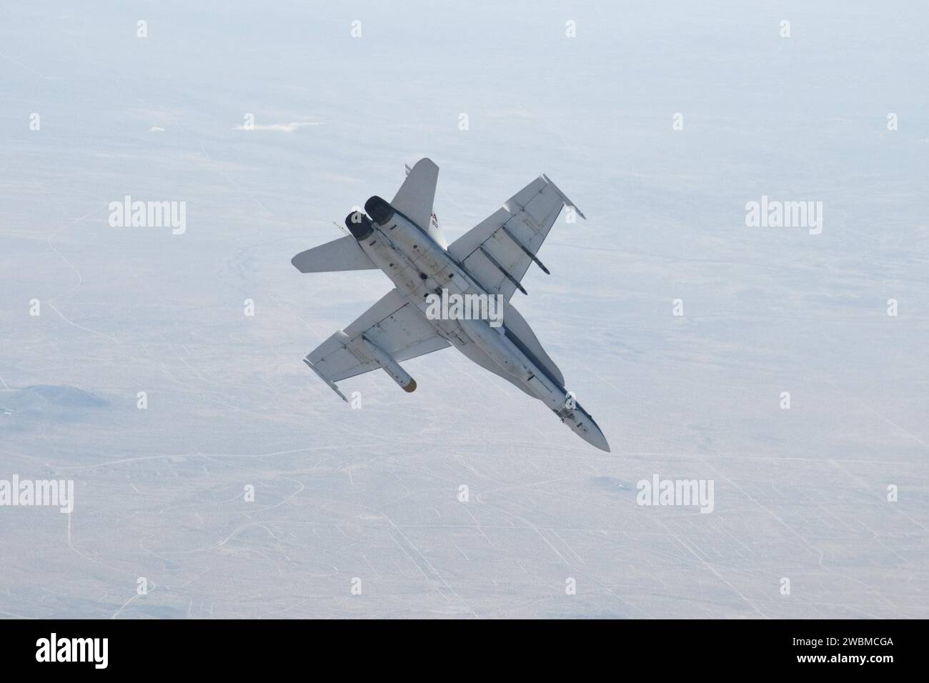 Un aereo F/A-18 del NASA Dryden Flight Research Center esegue manovre di volo durante i test di un prototipo di radar di atterraggio su Marte per la missione Mars Science Laboratory, alloggiato in un pod sotto l'ala sinistra. Foto Stock
