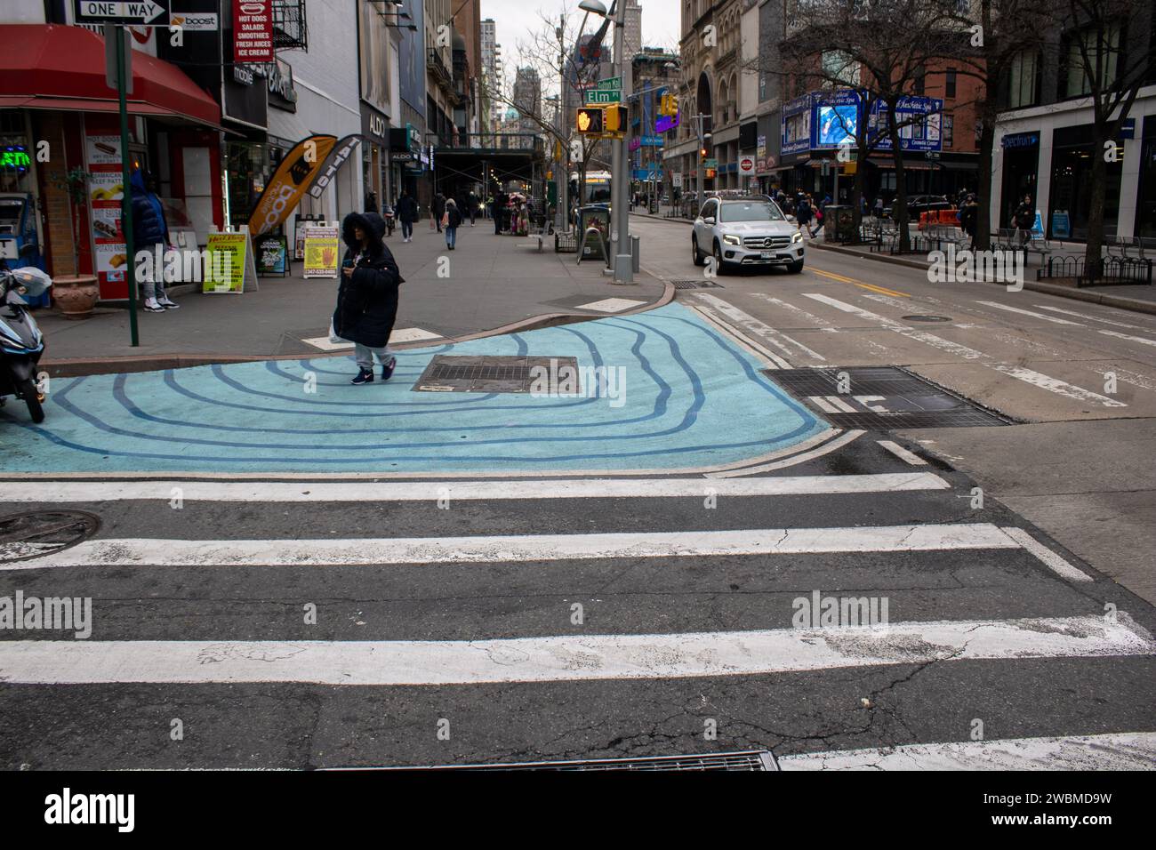 Un vivace crosswalk dipinto con linee ondulate in una fresca tonalità gialla Foto Stock