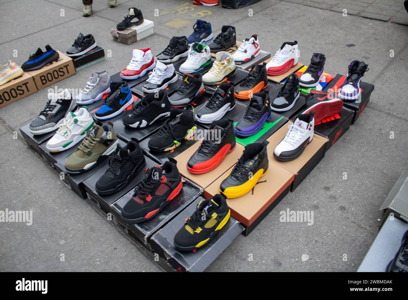 Una gamma di calzature assortite è esposta nelle scatole originali, creando un'accattivante esposizione di merchandising Foto Stock