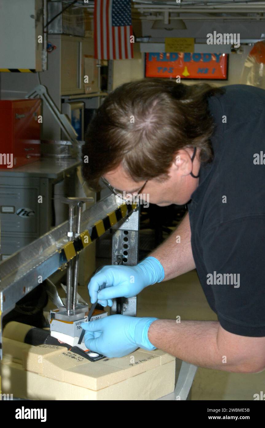 KENNEDY SPACE CENTER, FLA. - Nel vano 1 dell'Orbiter Processing Facility, il tecnico della United Space Alliance George Arnett lavora sul collegamento di piastrelle per l'orbiter Atlantis. L'orbiter è previsto per il volo di ritorno alla missione STS-121 nel mese di luglio. STS-121 è un ritorno al volo di utilità di volo e logistica (ULF-2) alla stazione spaziale Internazionale. Foto Stock