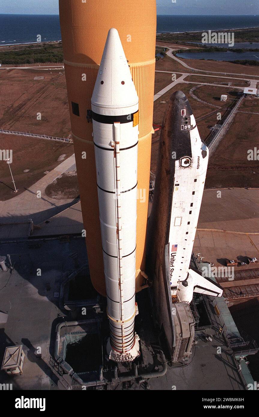KENNEDY SPACE CENTER, BAN. Riposando in cima alla piattaforma di lancio mobile, lo Space Shuttle Atlantis e' visto da un alto livello sulla struttura del servizio fisso. Visto è uno dei suoi booster a razzo solido e il serbatoio esterno. Accanto all'ala dell'orbiter si trova uno dei due montanti di servizio della coda, che supportano i requisiti fluidi, gas ed elettrici dell'ossigeno liquido e dell'idrogeno liquido dell'orbiter T-0 ombelicali. All'orizzonte c'è l'Oceano Atlantico. Atlantis volerà sulla missione STS-98, il settimo volo di costruzione verso la stazione spaziale Internazionale, trasportando il laboratorio statunitense, chiamato Destiny Foto Stock
