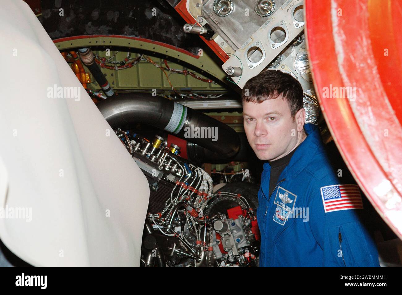 Lo specialista missione STS-114 James Kelly ispeziona i motori installati di recente sullo Space Shuttle Discovery nell'impianto di elaborazione Orbiter del Kennedy Space Center. Discovery è pronta per il lancio dal 12 maggio al 3 giugno 2005. Foto Stock