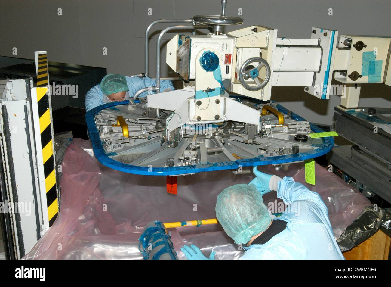 KENNEDY SPACE CENTER, FLA. - Nell'impianto di elaborazione della stazione spaziale, i lavoratori guidano uno dei portelli del modulo Node-2 su un container di spedizione. I portelli sono stati rimossi in preparazione per la spedizione al Marshall Space Flight Center, Ala., per la certificazione di riequilibrio. Il Node-2 verrà lanciato nella missione 10A, STS-120, verso la stazione spaziale Internazionale (ISS), attualmente prevista per l'autunno 2006. L'installazione del Node-2 sulla ISS significherà il completamento della fase di assemblaggio negli Stati Uniti e aumenterà lo spazio abitativo e di lavoro all'interno della stazione a circa 18.000 cubici Foto Stock