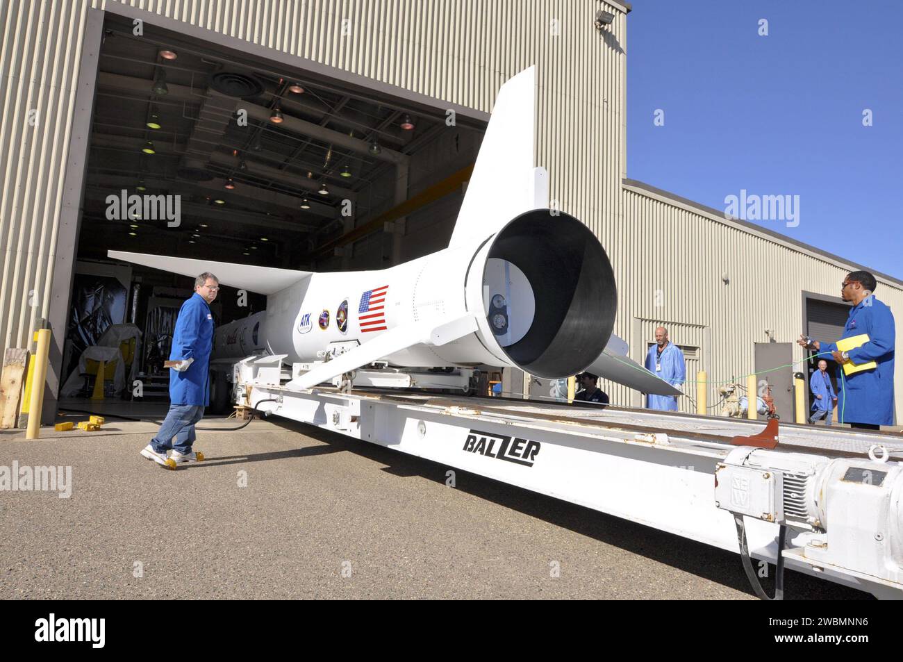 I tecnici della Vandenberg Air Force base monitorano il razzo Pegasus XL e il telescopio a raggi X NuSTAR su un trasportatore nell'hangar di Orbital. Il trasportatore sposterà il razzo sulla pista per l'attacco a un aereo L-1011 per il lancio verso l'atollo di Kwajalein per studiare buchi neri, resti di supernova, raggi cosmici e fisica stellare. Foto Stock