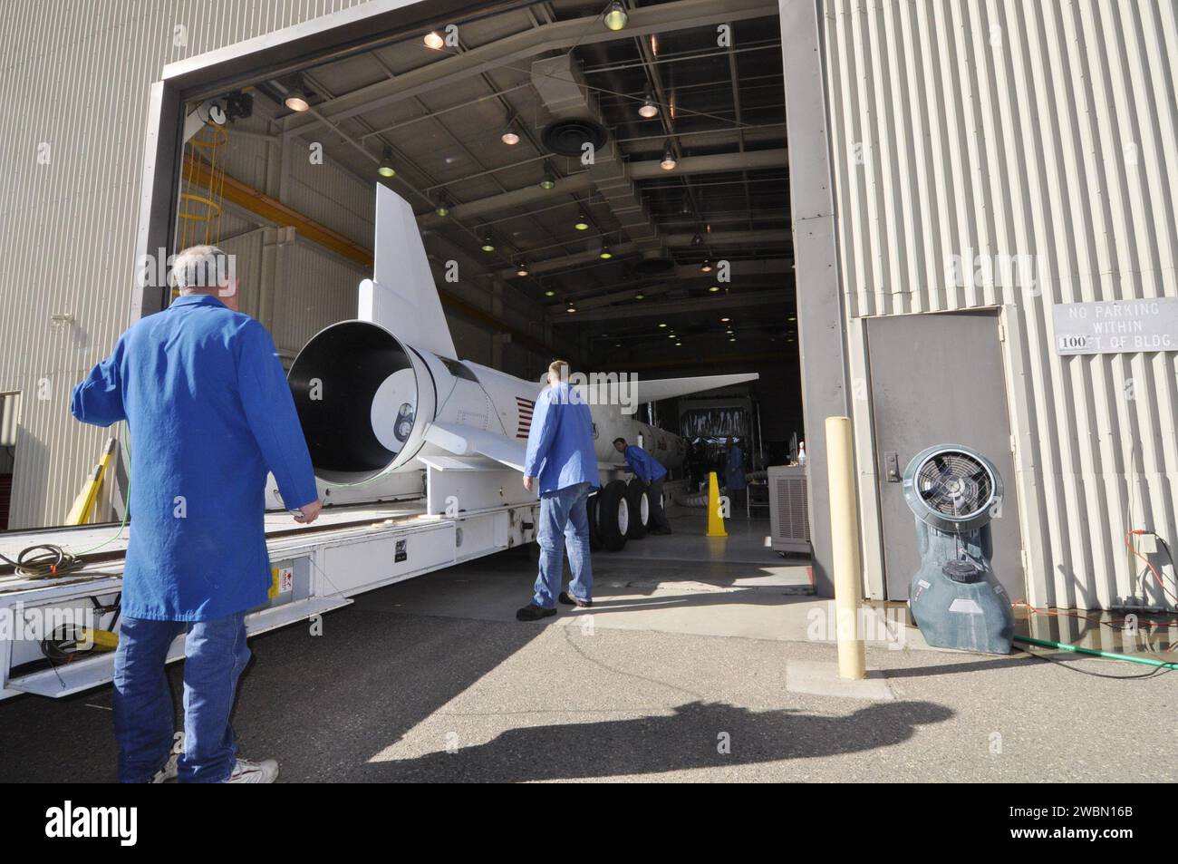 I tecnici della Vandenberg Air Force base monitorano il razzo Pegasus XL e il telescopio NuSTAR in quanto è posizionato sotto un trasportatore all'interno dell'hangar di Orbital prima di essere spostato sulla pista per il lancio per studiare buchi neri, resti di supernova, raggi cosmici e fisica stellare. Foto Stock