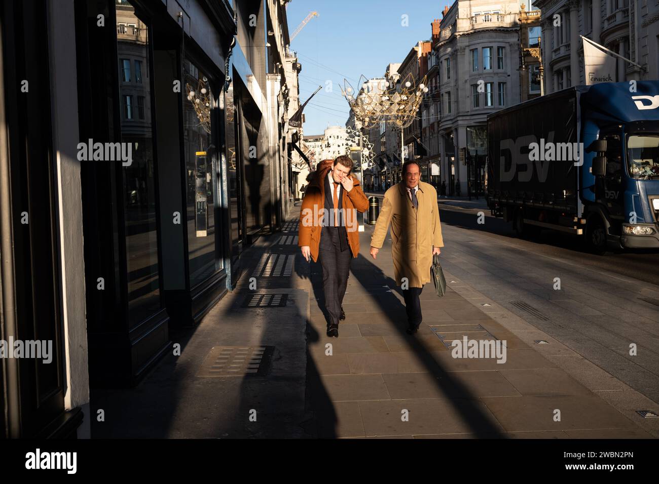 Gli uomini d'affari camminano lungo Old Bond Street, nella zona di Mayfair, in una fresca mattinata di gennaio mentre si recano al lavoro, Londra, Regno Unito Foto Stock
