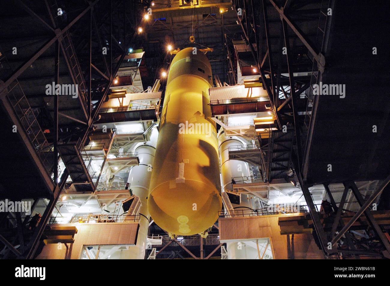 KENNEDY SPACE CENTER, FLA. - L'immensa dimensione del serbatoio esterno viene catturata qui mentre una gru lo abbassa tra i Solid Rocket Boosters (SRB) sulla piattaforma di lancio mobile. L'ET, designato per la missione di ritorno al volo STS-114, sarà accoppiato agli SRB per il lancio. Il ET lungo 154 piedi è stato recentemente riprogettato per soddisfare le raccomandazioni del Columbia Accident Investigation Board prima di tornare in volo. Tra le decine di modifiche è stato riprogettato un bipode anteriore per ridurre il rischio per lo Space Shuttle di cadere detriti durante la salita. Considerato un volo di prova, STS-114 è schedul Foto Stock