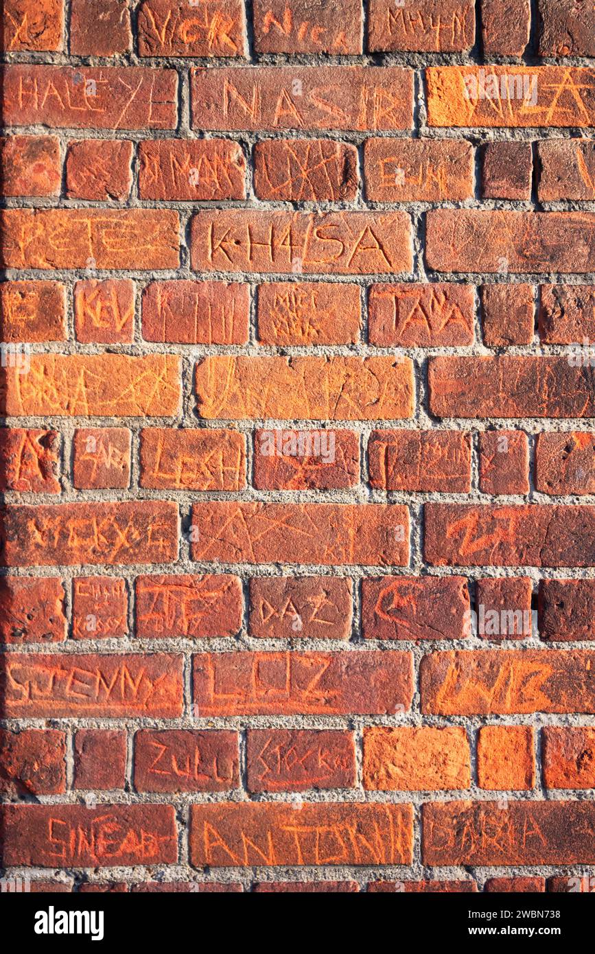 Nomi graffiati su un Brick Wall a Bedford Foto Stock