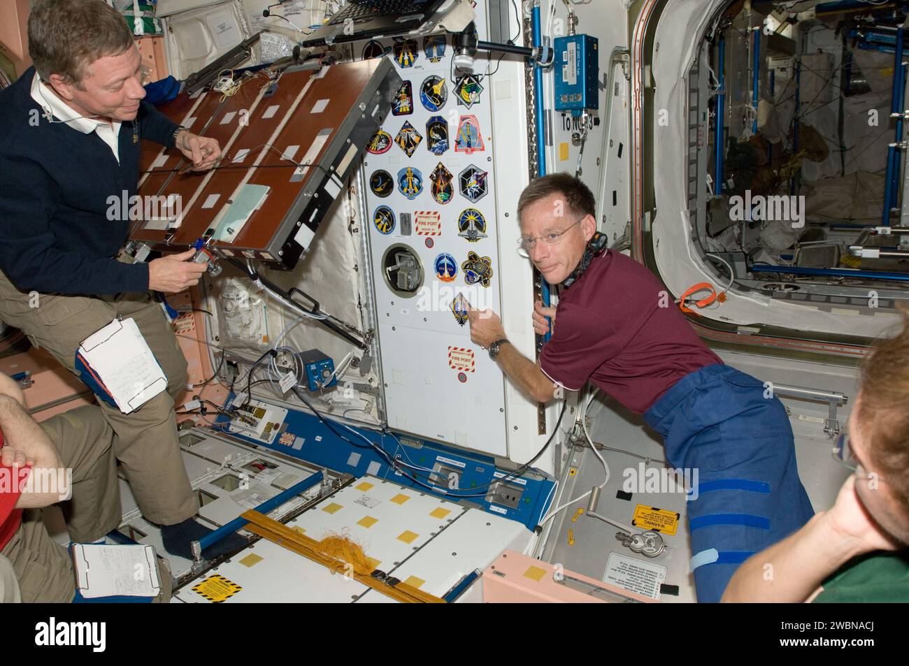 S135-e-009473 (18 luglio 2011) --- all'interno del nodo 1 o unità della stazione spaziale Internazionale, l'astronauta della NASA Chris Ferguson, comandante della STS-135, aggiunge la decalcomania della sua missione come pezzo finale della collezione di insegne dell'equipaggio dello shuttle. L'astronauta della NASA Mike Fossum, ingegnere di volo della Expedition 28, guarda. Foto Stock