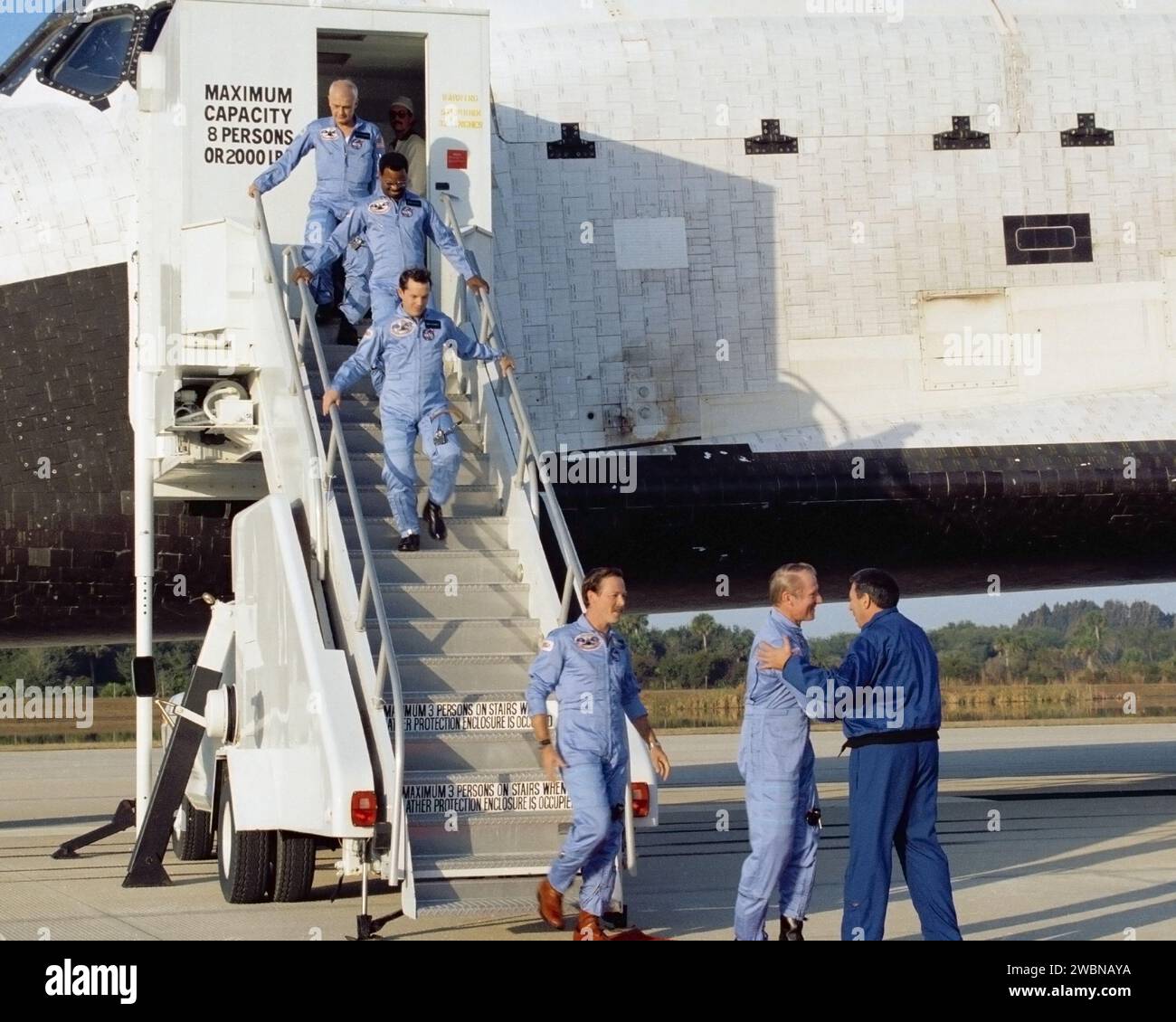 CAPE CANAVERAL, Ban. -- l'equipaggio del 41B STS-11, il primo volo spaziale della storia ad iniziare e concludere una missione nello stesso sito, lascia il ponte di volo dell'orbiter Challenger per essere accolto da George Abbey, direttore delle operazioni dell'equipaggio di volo. In ordine ascendente, i membri dell'equipaggio sono Vance Brand, il comandante di missione il pilota di missione Robert L.'Hoot' Gibson e gli specialisti di missione Robert L. Stewart, Ronald E. McNair e Bruce McCandless II Challenger atterrò alle 7 15 55 EST dell'11 febbraio, rotolando per 10.700 metri prima di fermarsi sulla pista lunga 000 metri del Kennedy Space Center. Foto Stock