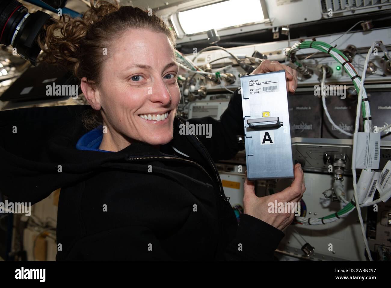 Iss070e037585 (11 dicembre 2023) --- astronauta NASA e ingegnere Flught Expedition 70 Loral o'Hara mostra hardware di ricerca a supporto dell'UMAMI, o comprensione della microgravità sull'interazione animale-microbo, esperimento di biologia spaziale. O'Hara ha in programma la cassetta per l'elaborazione dei fluidi (FPC) dell'Avanced Space Experiment Processor (ADSEP) che supporta l'osservazione degli effetti del volo spaziale sulle interazioni molecolari e chimiche tra microbi benefici e i loro ospiti animali. Foto Stock