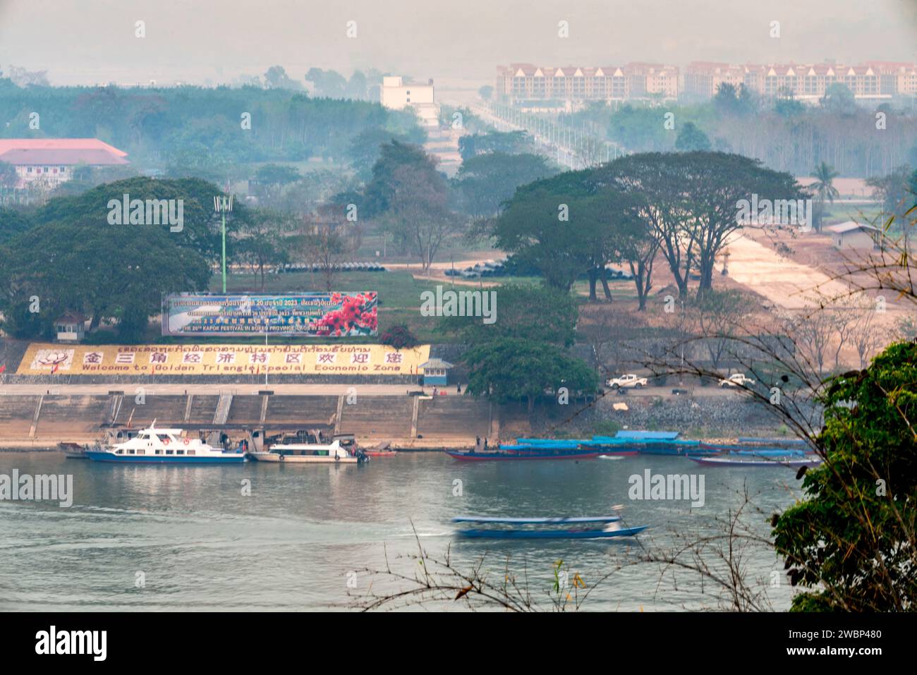Provincia di Chiang Rai, Thailandia del Nord - marzo 30 2023: Vista dal lato tailandese del fiume, durante la stagione della combustione di piante fumose, battelli per la gente Foto Stock