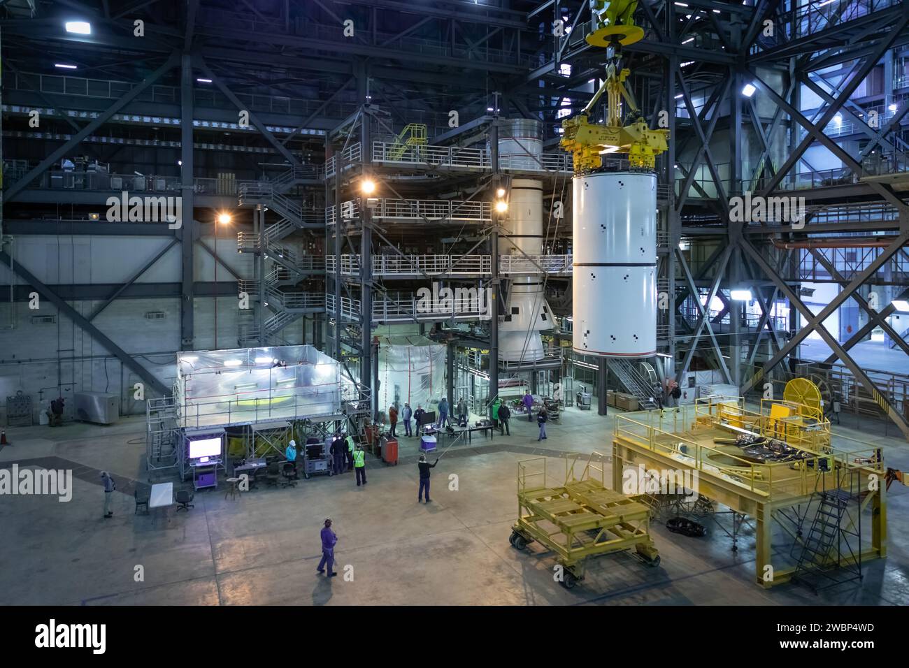 Nell'High Bay 4 del Vehicle Assembly Building presso il Kennedy Space Center della NASA in Florida, una gru sposta i segmenti pathfinder del booster a razzo solido Space Launch System (SLS) per impilarli sopra altri segmenti pathfinder durante un esercizio di addestramento l'8 gennaio 2020. Un team di ingegneri con Exploration Ground Systems e operatori di gru e tecnici con l'appaltatore Jacobs stanno esercitando le manovre di sollevamento, spostamento e impilamento, utilizzando importanti attrezzature di supporto a terra per formare i dipendenti e certificare che tutte le attrezzature funzionano correttamente. I Pathfinder del booster sono repliche inerti a scala reale Foto Stock