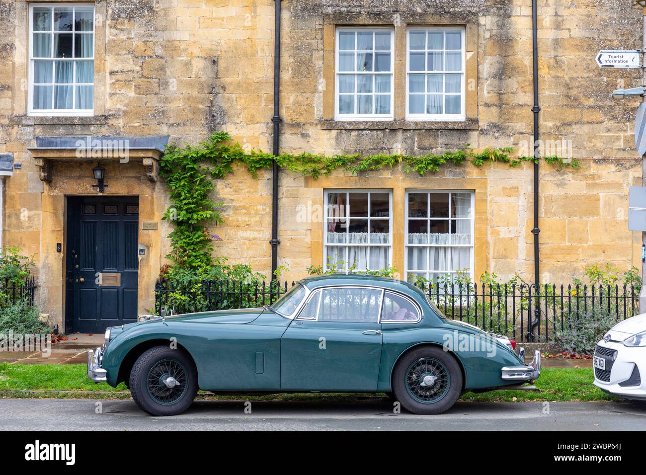 Auto sportiva Jaguar XK classica parcheggiata all'esterno di una proprietà in pietra del cotswold nella città mercato di Chipping Campden, Inghilterra, Regno Unito, 2023 Foto Stock