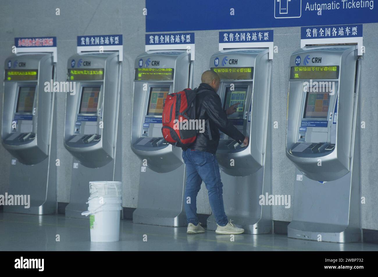 HANGZHOU, CINA - 12 GENNAIO 2024 - Un passeggero acquista un biglietto del treno presso una biglietteria automatica presso la biglietteria della stazione ferroviaria di Hangzhou in Foto Stock