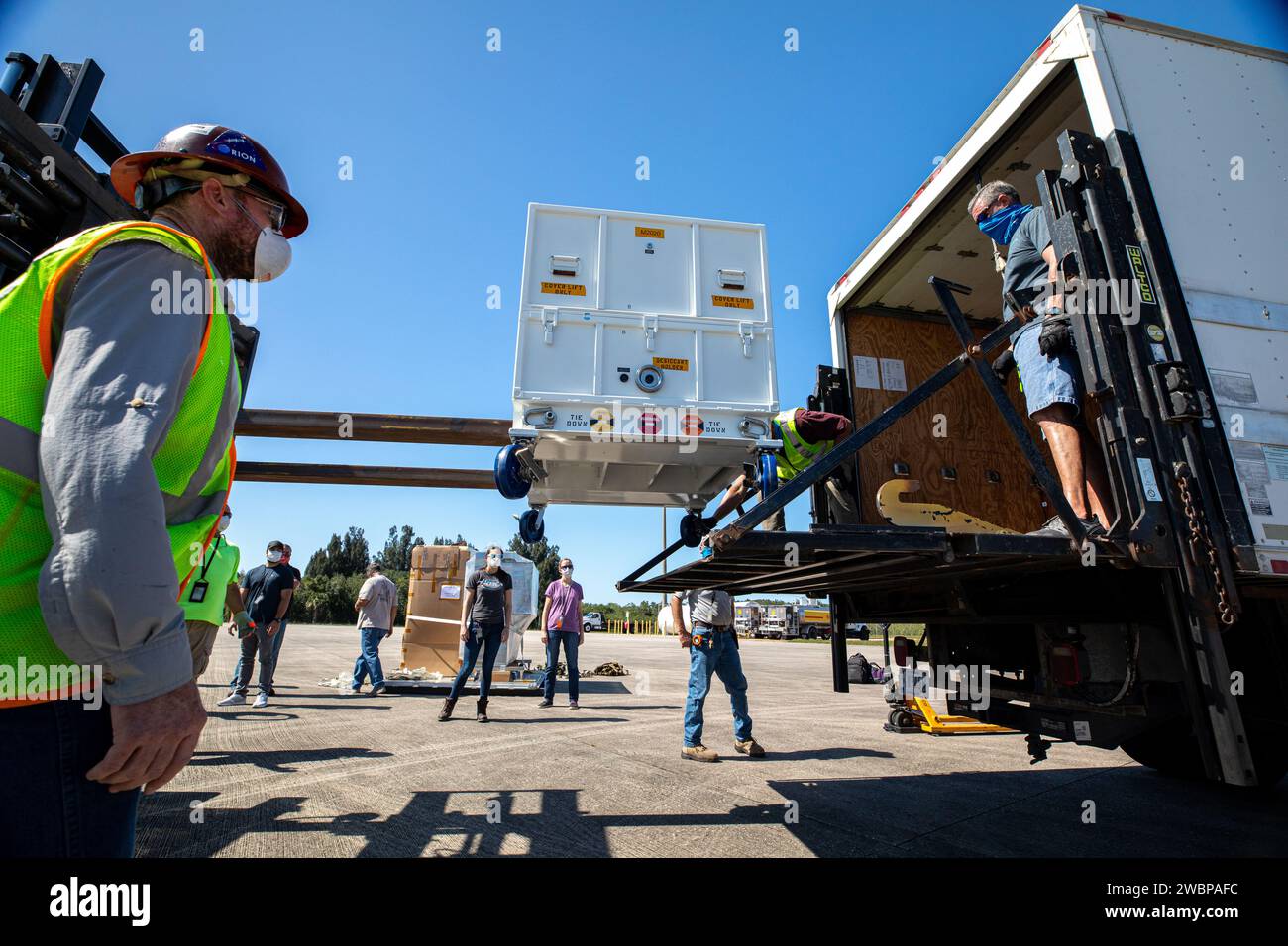 I lavoratori utilizzano uno speciale dispositivo di movimentazione per scaricare l'Adaptive Caching Assembly (ACA) per il rover Mars Perseverance della NASA dall'aereo C-130 dell'agenzia presso la Launch and Landing Facility del Kennedy Space Center in Florida l'11 maggio 2020. L'ACA è composto da sette motori e più di 3.000 parti, tutti in sinergia per raccogliere campioni dalla superficie di Marte. Un componente principale del gruppo è il braccio per la manipolazione dei campioni, che sposta le provette dei campioni nell'unità di carotaggio del braccio robotizzato principale e quindi trasferisce le provette riempite in uno spazio da sigillare e conservare. Il rover Mars Perseverance Foto Stock