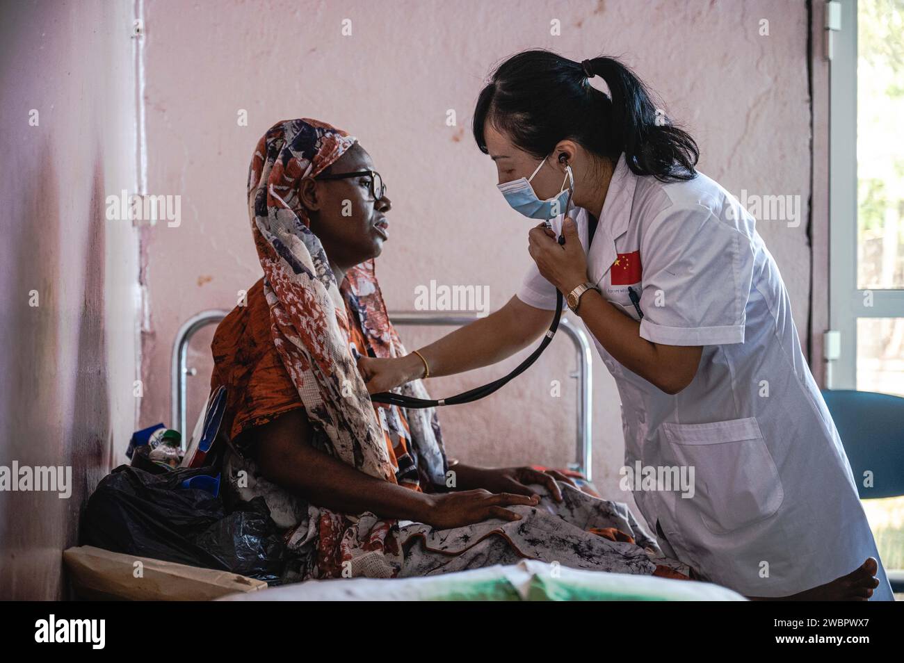 Moroni, Comore. 11 gennaio 2024. Xu Rongting, membro dell'equipe medica cinese, visita un paziente all'ospedale El-Maarouf di Moroni, capitale delle Comore, 11 gennaio 2024. L'equipe medica della regione autonoma del Guangxi Zhuang del sud della Cina è arrivata nelle Comore nel 2022, fornendo servizi medici per i pazienti locali e la formazione per i medici locali. Crediti: Wang Guansen/Xinhua/Alamy Live News Foto Stock