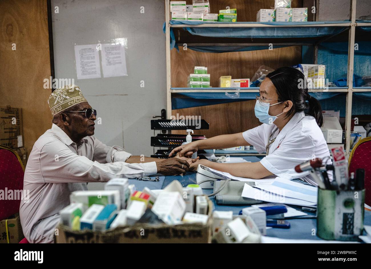 Moroni, Comore. 11 gennaio 2024. Pan Chunxi, capo dell'equipe medica cinese alle Comore, visita un paziente all'ospedale El-Maarouf di Moroni, capitale delle Comore, 11 gennaio 2024. L'equipe medica della regione autonoma del Guangxi Zhuang del sud della Cina è arrivata nelle Comore nel 2022, fornendo servizi medici per i pazienti locali e la formazione per i medici locali. Crediti: Wang Guansen/Xinhua/Alamy Live News Foto Stock