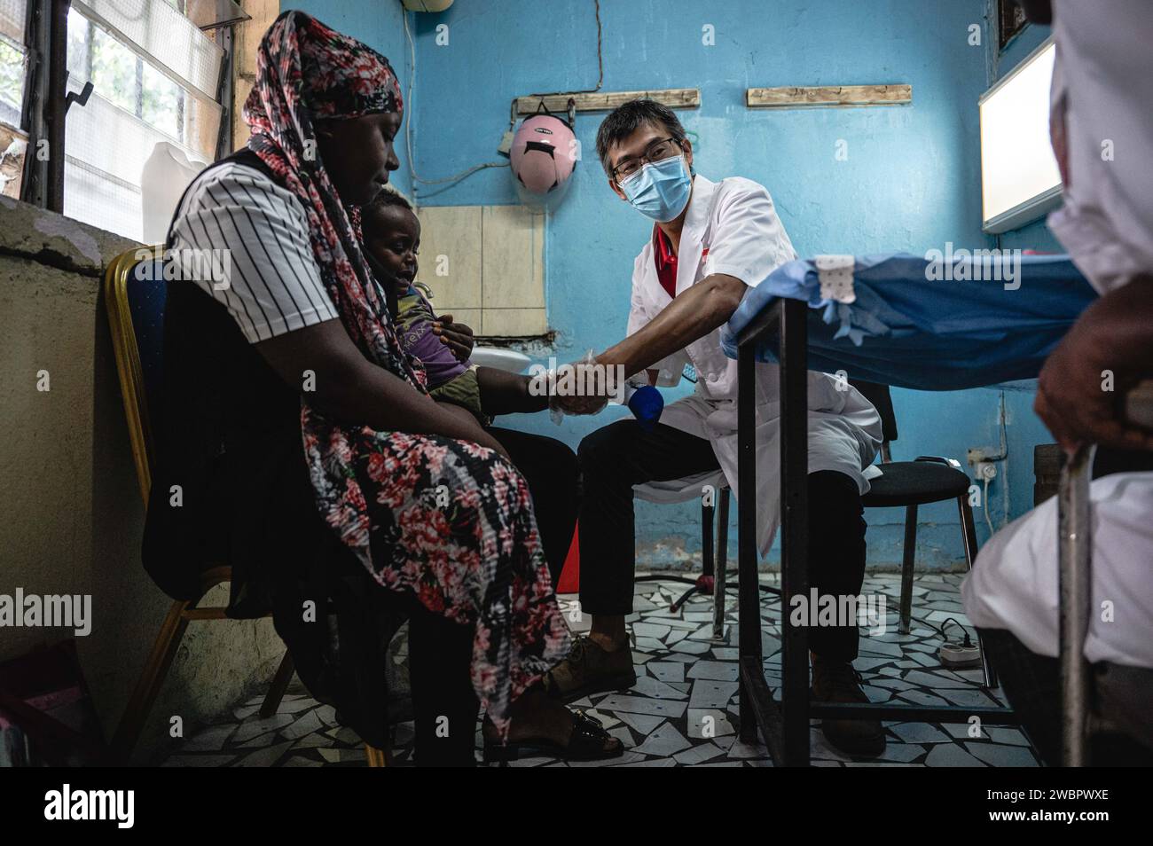 Moroni, Comore. 11 gennaio 2024. BEI Yunfeng, membro del team medico cinese e chirurgo, visita un paziente presso l'ospedale El-Maarouf di Moroni, capitale delle Comore, 11 gennaio 2024. L'equipe medica della regione autonoma del Guangxi Zhuang del sud della Cina è arrivata nelle Comore nel 2022, fornendo servizi medici per i pazienti locali e la formazione per i medici locali. Crediti: Wang Guansen/Xinhua/Alamy Live News Foto Stock