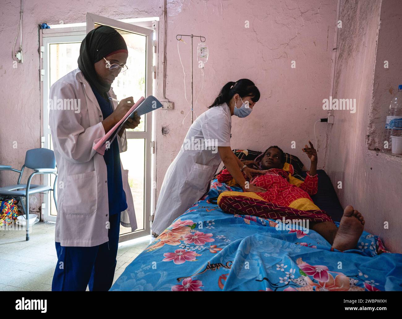 Moroni, Comore. 11 gennaio 2024. Xu Rongting, membro dell'equipe medica cinese, visita un paziente all'ospedale El-Maarouf di Moroni, capitale delle Comore, 11 gennaio 2024. L'equipe medica della regione autonoma del Guangxi Zhuang del sud della Cina è arrivata nelle Comore nel 2022, fornendo servizi medici per i pazienti locali e la formazione per i medici locali. Crediti: Wang Guansen/Xinhua/Alamy Live News Foto Stock