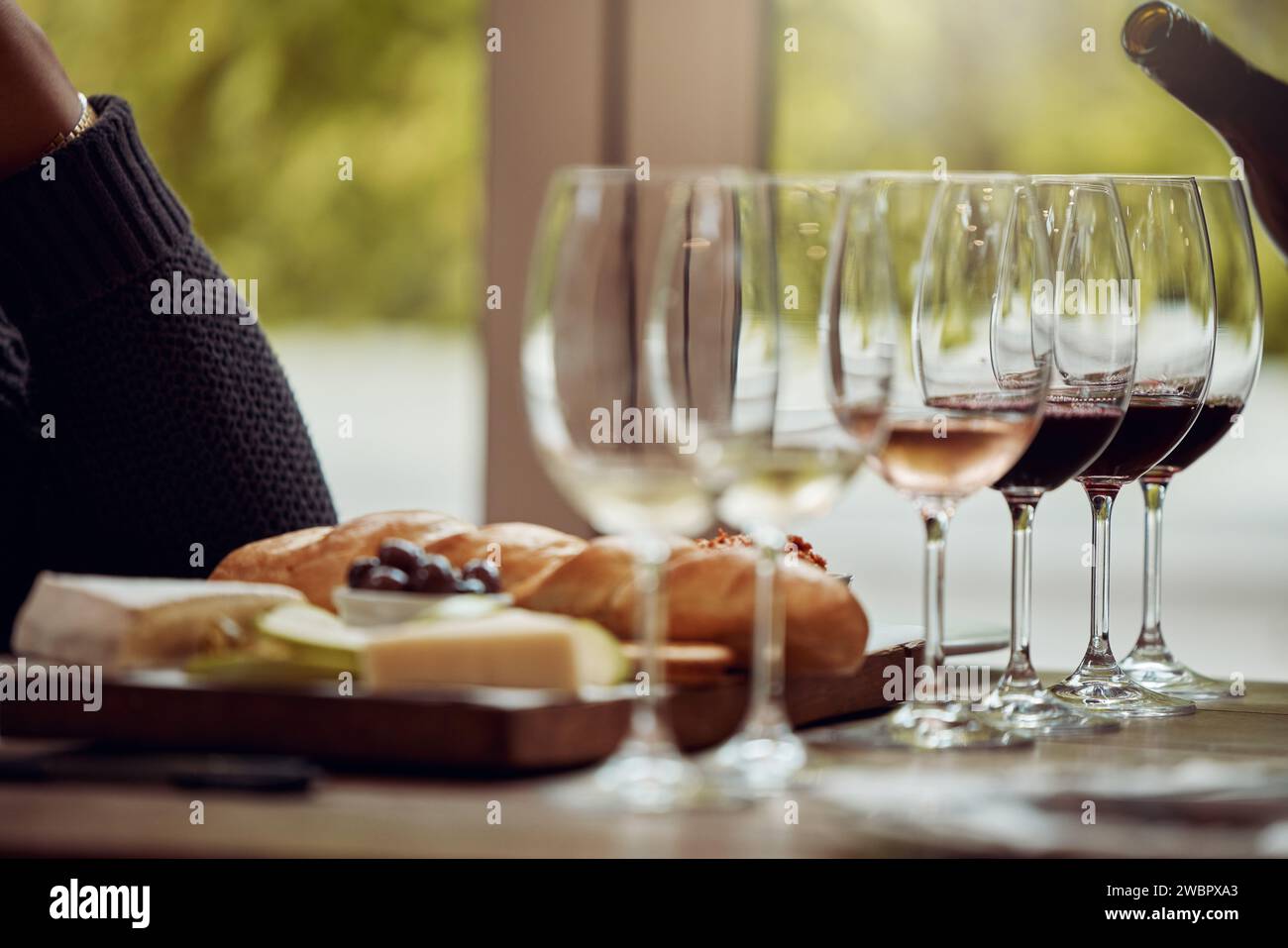 Degustazione di vini, vassoio di formaggi e ristorante con vino e bicchiere per il cliente. Cameriere, drink e sommelier con bottiglia per vini e cibo Foto Stock