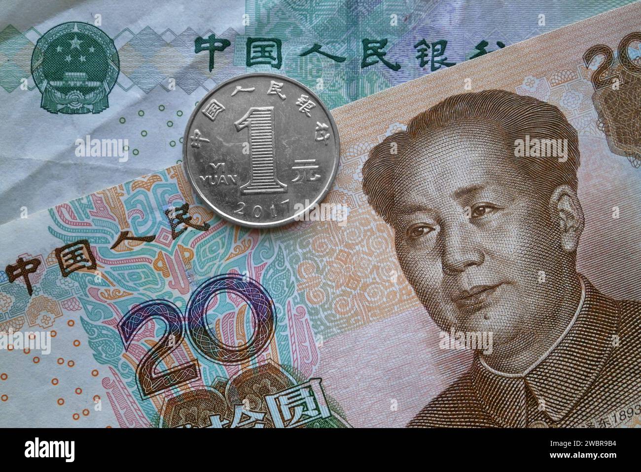 Una moneta da 1 yuan sopra una banconota da 20 yuan e una banconota da 50 yuan. Foto Stock